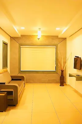 a living room with a couch and a large screen at Mist Wayanad in Wayanad