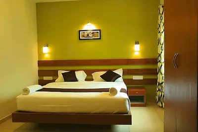 a bedroom with a bed and a yellow wall at Mist Wayanad in Wayanad