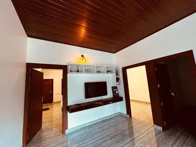 a living room with a flat screen tv on a wall at Mist Wayanad in Wayanad