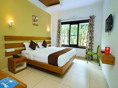 a bedroom with a large bed and a window at Mist Wayanad in Wayanad