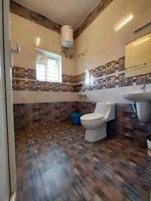 a bathroom with a toilet and a sink at Serenity inn - Rose Garden in Ooty