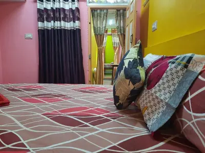 a bedroom with a bed with pillows on it at Green Land Estate Homestay 5 Rooms With Garden View in Madikeri
