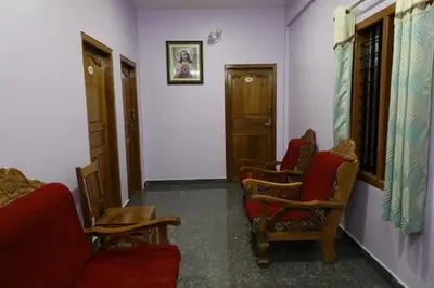 a hallway with two chairs and a red couch at Ammukutty's Cottage in Munnar