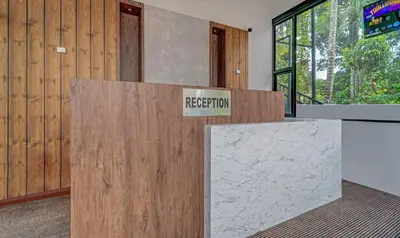 a reception desk in a room with a sign on it at Treebo Regalia Inn Wayanad With Swimming Pool in Kalpetta