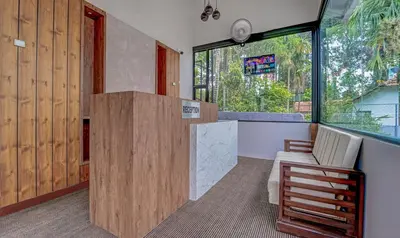 a room with a counter with a chair and a window at Treebo Regalia Inn Wayanad With Swimming Pool in Kalpetta