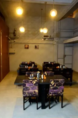 a dining room with tables and chairs and lights at Vanam Holidays in Ooty