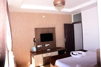 a hotel room with a bed and a television at Vanam Holidays in Ooty
