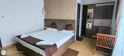 a bedroom with a bed with white towels on it at Vanam Holidays in Ooty