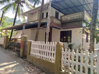 a white picket fence in front of a house at Homely Homes in Kalpetta