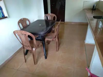 a dining room table and four chairs in a kitchen at Homely Homes in Kalpetta