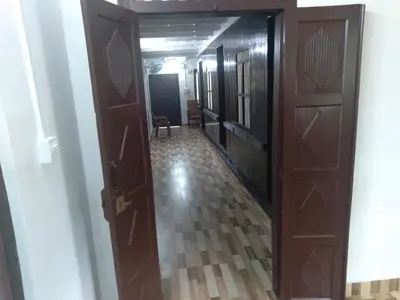 a hallway with two wooden doors and a floor at Homely Homes in Kalpetta
