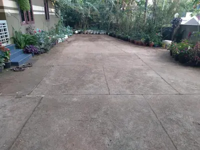 an empty driveway with potted plants in a yard at Homely Homes in Kalpetta