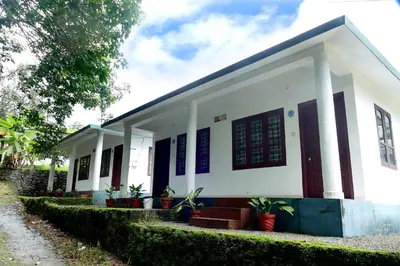 a small white building with plants in front of it at Mountain View cottage Mankulam in Munnar