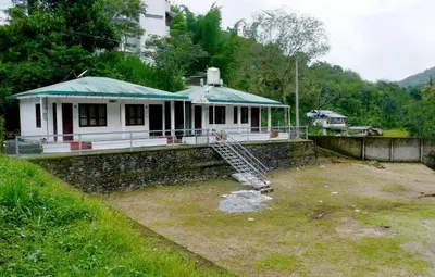 a small white house with a green roof at Mountain View cottage Mankulam in Munnar