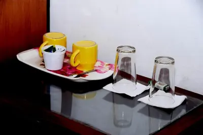a table with two glasses and a plate with aucer at Mountain View cottage Mankulam in Munnar