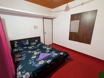 a bedroom with a bed and a wooden door at kaffee valley - Kurumbalakotta in Padinjarathara