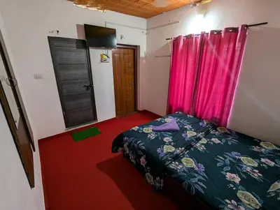 a bedroom with a bed and pink curtains and a door at kaffee valley - Kurumbalakotta in Padinjarathara