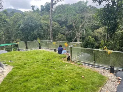 a person sitting on top of a field of grass at Rai’s Coorg Cave House in Madikeri