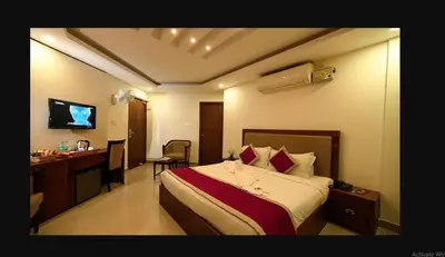 a hotel room with a bed and a desk and a television at Rotano Glitz Inn - Glitz Inn Calicut in Kozhikode