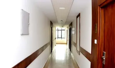 a corridor of a hallway with a door and a hallway sidx sidx at Rotano Glitz Inn - Glitz Inn Calicut in Kozhikode
