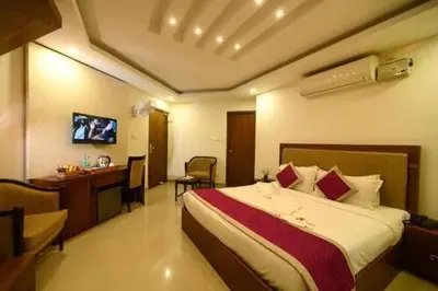 a hotel room with a bed and a desk at Rotano Glitz Inn - Glitz Inn Calicut in Kozhikode
