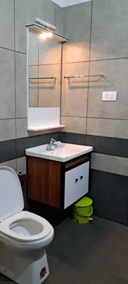 a bathroom with a toilet and a sink and a mirror at The Lavender Woods in Vythiri