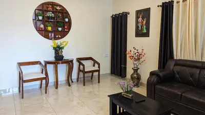 a living room with a couch and a table and chairs at SindooRa in Mysore