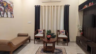 a living room with a couch and a tv at SindooRa in Mysore