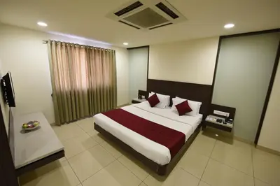 a bedroom with a large bed with red pillows at Hotel LandmarK Coimbatore in Coimbatore