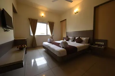 a bedroom with a bed and a television in it at Hotel LandmarK Coimbatore in Coimbatore