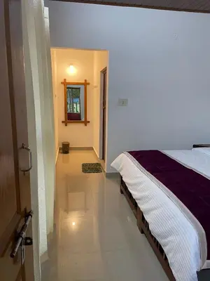 a bedroom with a bed and a door to a hallway at Wild Valley Club in Masinagudi