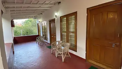 a room with a door and chairs and a table at Wild Valley Club in Masinagudi