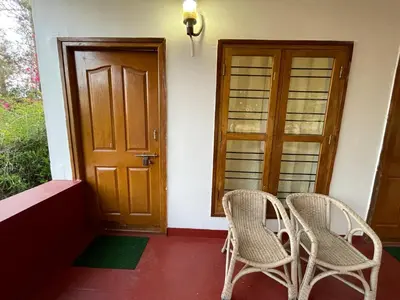 a pair of chairs sitting in front of a door at Wild Valley Club in Masinagudi