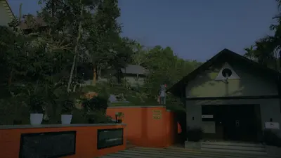 a small building with an orange fence and trees at Mountain Vibes Resort Wayanad in Wayanad