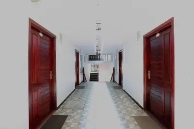 a hallway with two doors and a tile floor at Pinehill Suites in Ooty