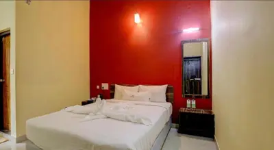 a bedroom with a white bed with a red wall at Lazo Areca Resort , Coorg in Madikeri