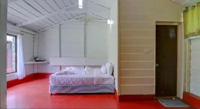 a bedroom with a bed in the middle of a room at Lazo Areca Resort , Coorg in Madikeri