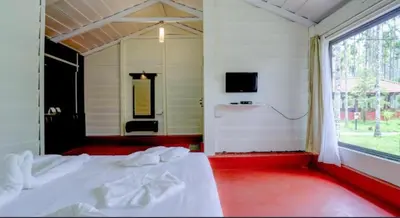 a bedroom with a white bed and a window at Lazo Areca Resort , Coorg in Madikeri