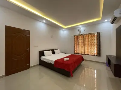 a bedroom with a bed with a red blanket and a window at SkYVIEW VILLA in Athirappilly