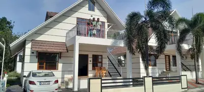 a family on the balcony of their house at SkYVIEW VILLA in Athirappilly