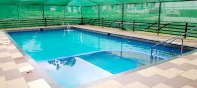 a large swimming pool with blue water in a tent at SkYVIEW VILLA in Athirappilly
