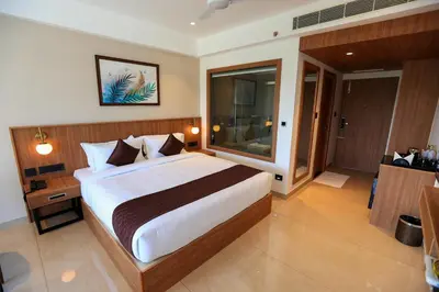 a bedroom with a large bed in a room at Hotel Saffron Wayanad in Sultan Bathery