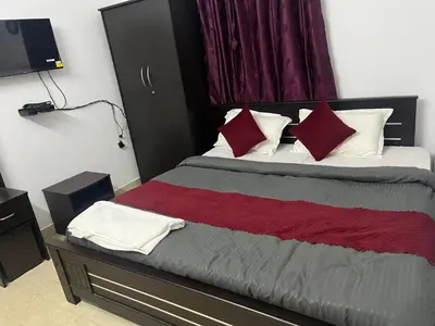 a bedroom with a bed with red and white pillows at REHMANS HOMESTAY in Ooty