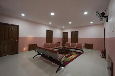 a waiting room with chairs and a table in it at Hotel Jothi Grand in Coimbatore