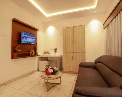 a living room with a couch and a tv at Hotel Vrindavan in Wayanad