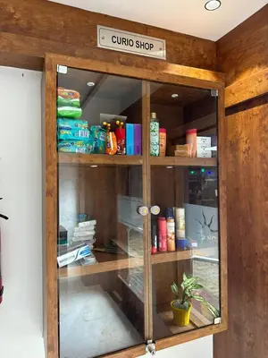 a glass cabinet with a sign that reads quino shop at Hotel Vrindavan in Wayanad