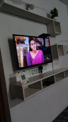 a flat screen tv sitting on a entertainment center at Oxygen Home Stay in Agali