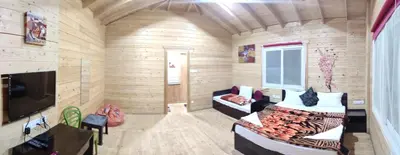 a wooden room with a couch and a tv at The Laughing Woods AC Resort in Kotagiri