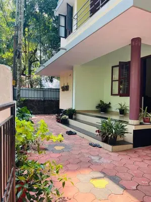 a house with a brick patio in front of a building at Ocean Pearl in Kozhikode