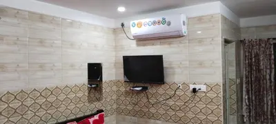 a living room with a tv and a wall with alevision at SAMPATH RESIDENCY in Palani
